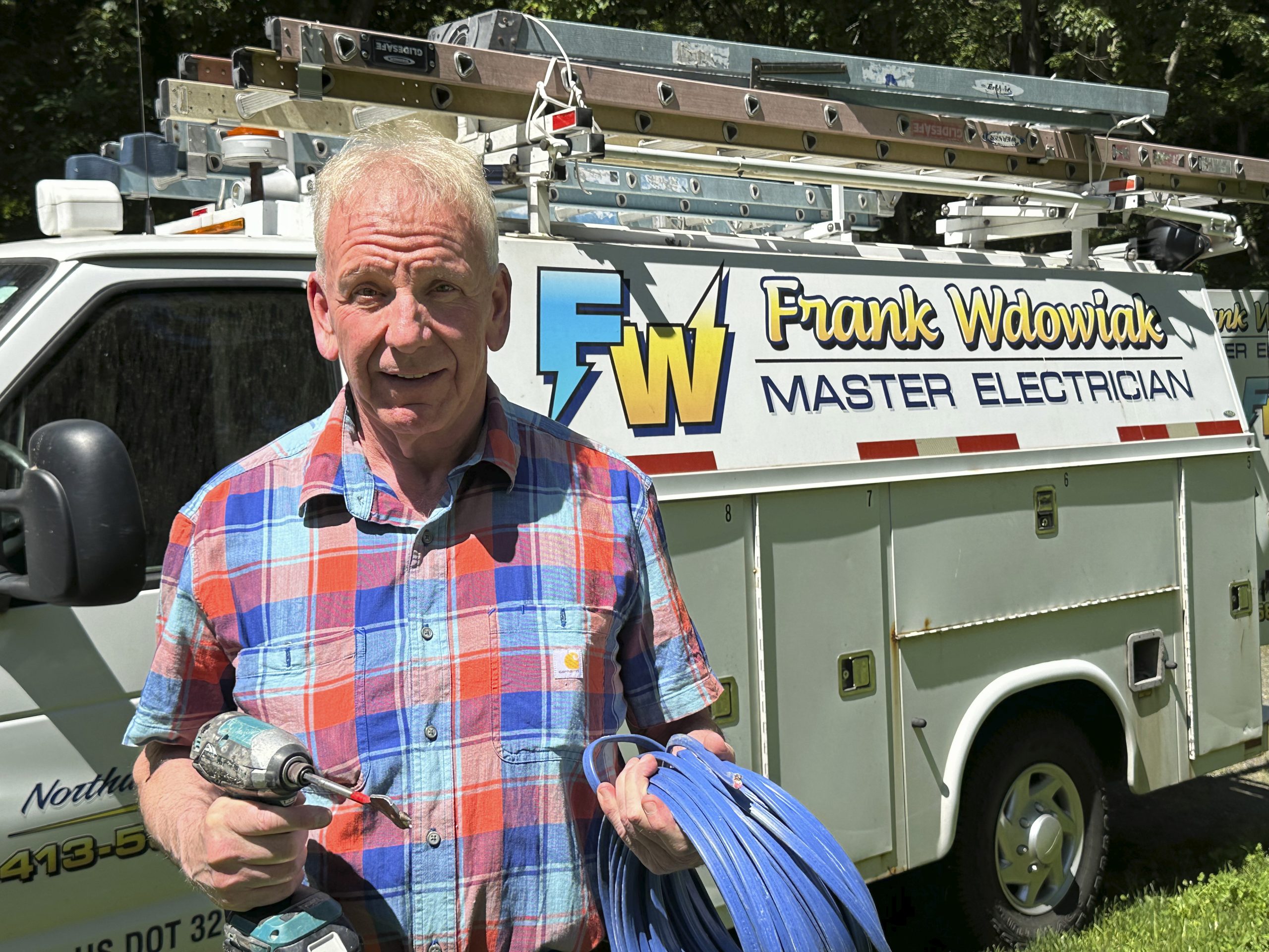 Frank Wdowiak holding tools in front of truck